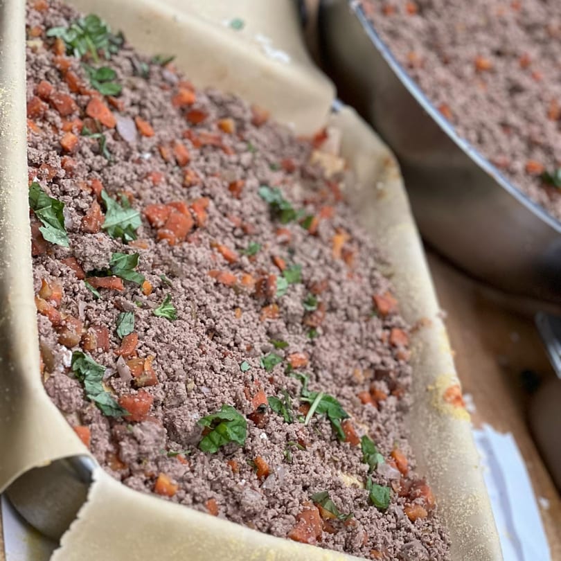 Close-up of Tino's Delicatessen's Italian meat pie filling with ground meat, carrots, and herbs.